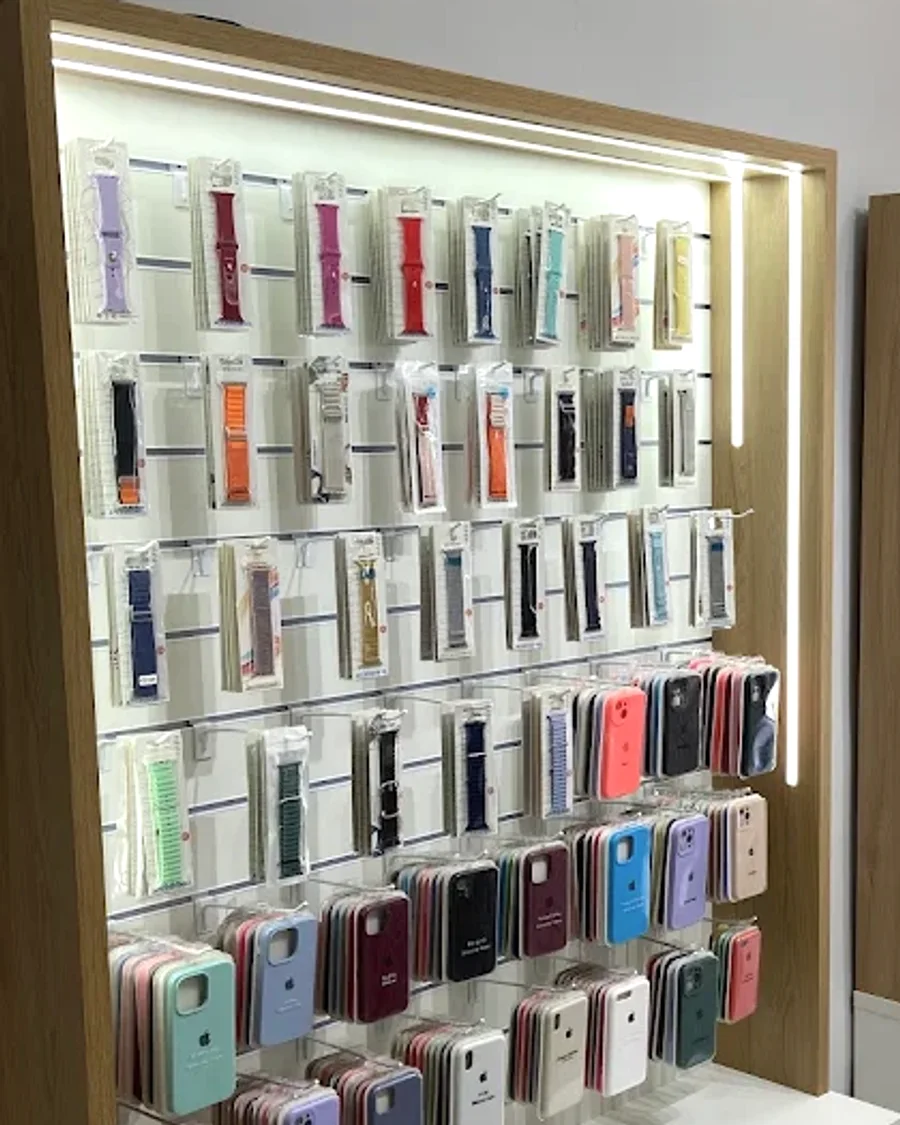 Parede de acessórios da Pró iPhones, com pulseiras de Apple Watch e capas de iPhone